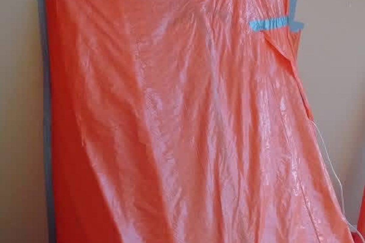 Doorway sealed with orange polyethylene sheeting for asbestos containment