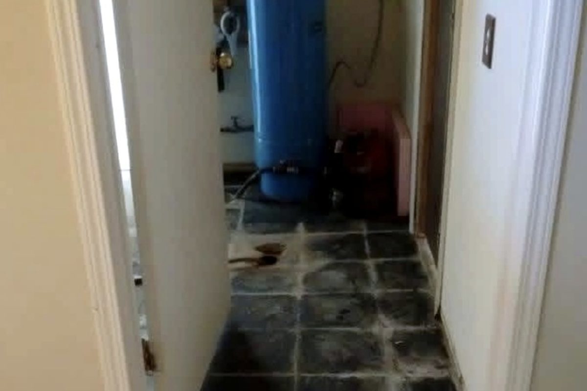 Hallway with carpet removed exposing old floor tile underneath